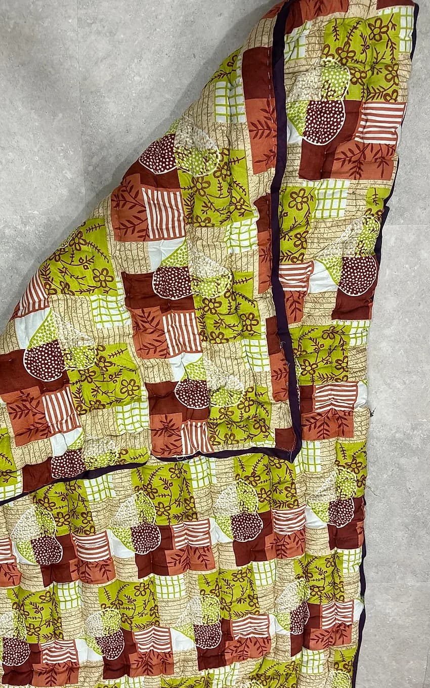 Earthy terracotta, olive, and brown geometric patchwork quilted razai with folded corner