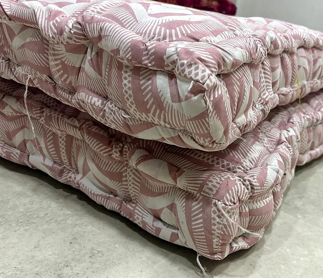 Corner close-up of stacked dusty rose diamond tufted gaddas
