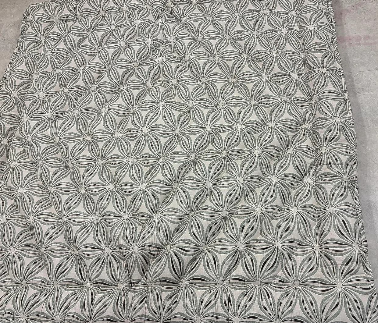 Neutral geometric starburst print quilted gadda laid out flat