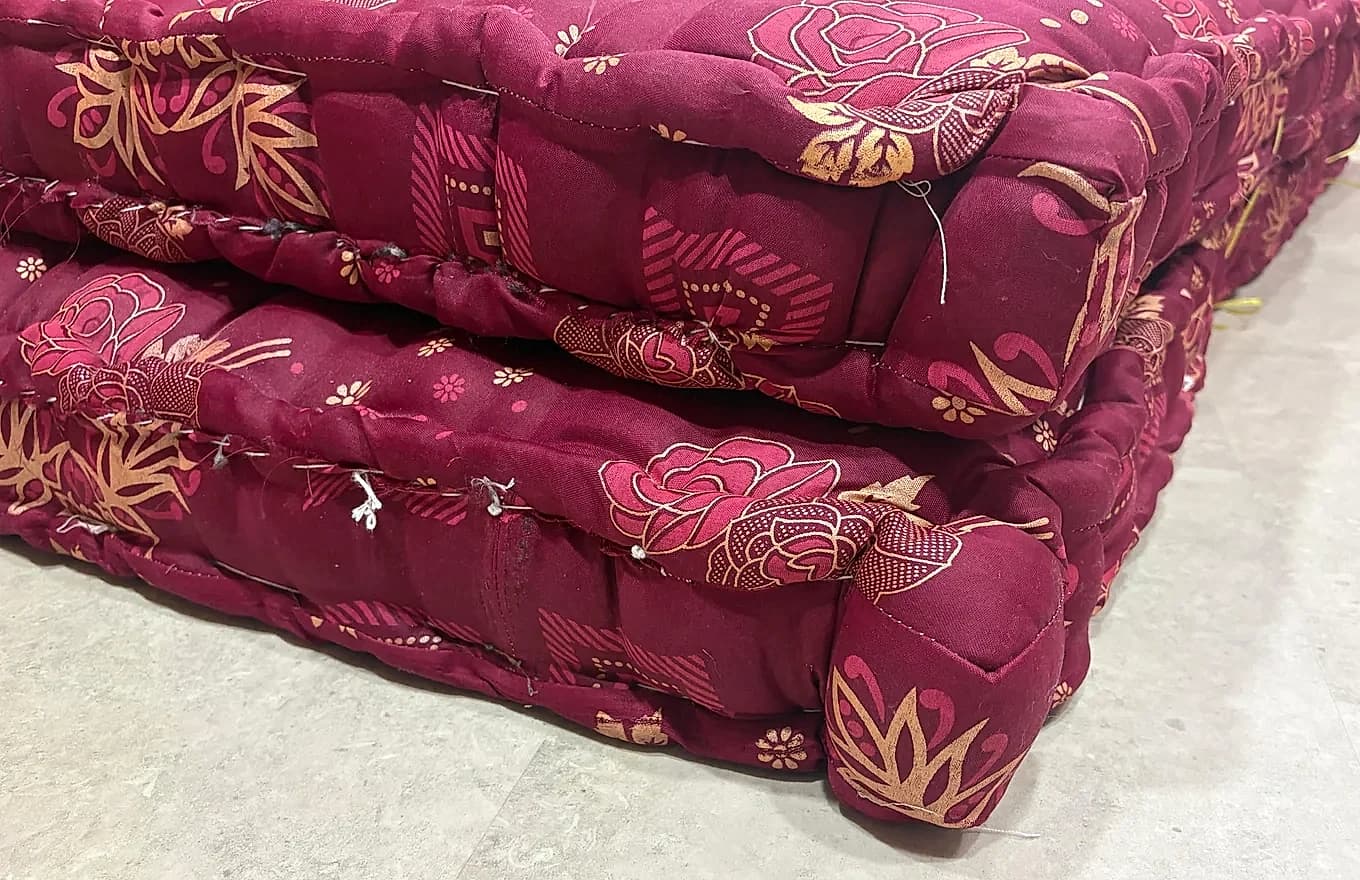 Stack of thick boxed-edge mattresses showing reinforced sidewall stitching